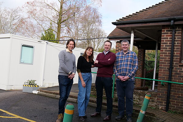 Lib Dems stand in a line in front of Bishop's Waltham GP surgery